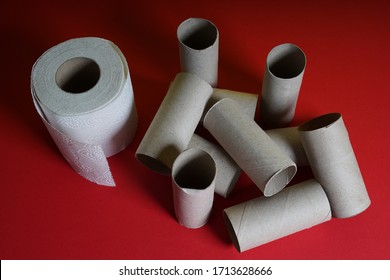 A Roll Of Toilet Paper Next To An Empty Roll Of Toilet Paper On A Red Shelf. Close Up Viewed From Above