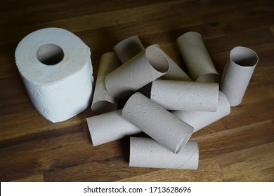 A Roll Of Toilet Paper, Running Out Of Empty Toilet Paper Roll, On A Brown Floor. Seen From Above