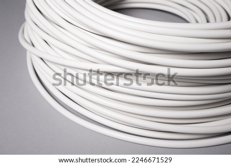 Roll of white electric cable wire on grey background