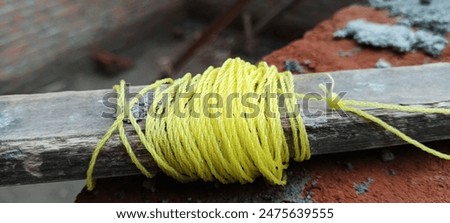 a roll of yellow plastic rope thread