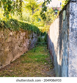 Rolle, Switzerland - September 05 2020 : An Mysterious Looking Back Alley With Walls With Ivy Giving It A Mysterious Look