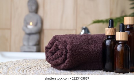 Rolled Bath Towel And Different Cosmetic Products On Table In Bathroom, Closeup