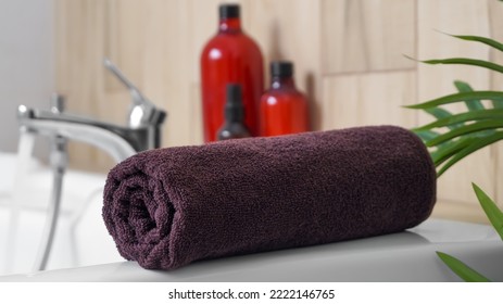 Rolled Bath Towel On Tub In Bathroom