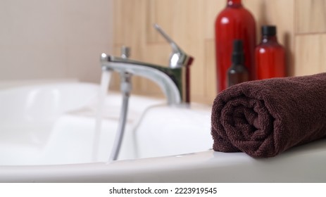 Rolled Bath Towel On Tub In Bathroom, Space For Text