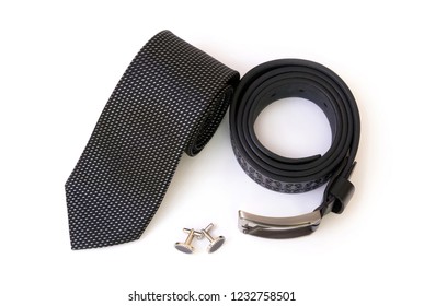 Rolled Black Men's Tie And A Leather Belt With A Couple Of Cuff Links Isolated On White Background, Top View