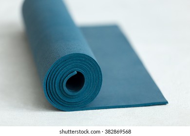 Rolled Up Blue Yoga, Pilates Or Exercise Mat On The Floor, Close Up