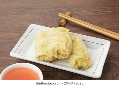 Rolled Chinese cabbage (Sawi Gulung Tahu) with tofu and chilli sauce
 - Shutterstock ID 2343478025