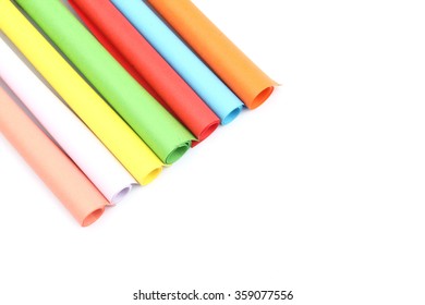 Rolled colorful paper on white background