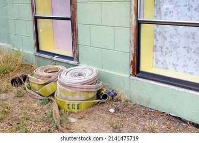 Rolled Up Fire Hoses Next To Green Wall, Antelope, Oregon, USA