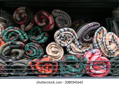 Rolled fleece blankets for sale on a shelf in a supermarket