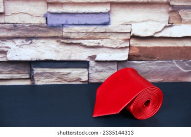 rolled formal necktie red coloured bricks wall background close up shot single object noperson 
