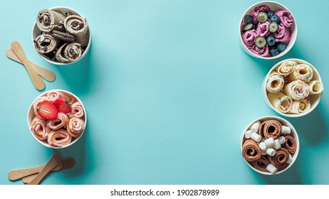 rolled ice creams in cone cups on blue background. Different iced rolls top view or flat lay. Thai style rolled ice cream with copy space in center for text or design. Banner