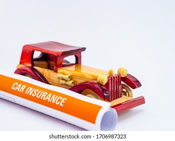 Rolled Insurance Document With A Wooden Vintage Toy Car, Shot Ag