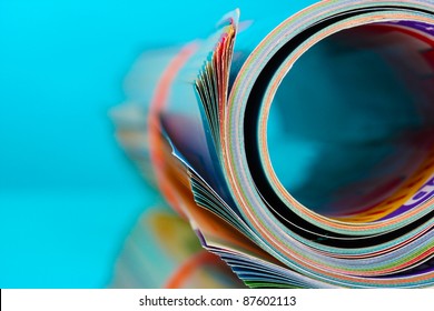 Rolled Up Magazines On Blue Background