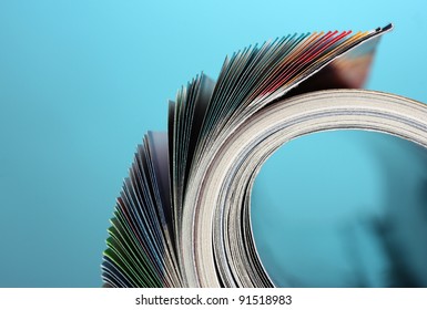 Rolled Up Magazines On Blue Background