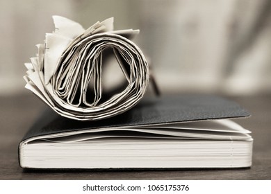 Rolled Newspaper And Business Notebook, Close Up