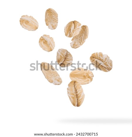 Rolled oat flakes falling on white background