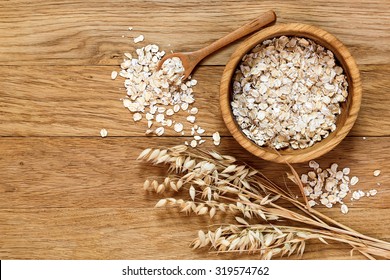 Rolled Oats And Oat Ears Of Grain On A Wooden Table, Copy Space