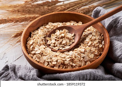 Rolled Oats Or Oat Flakes In Bowl With Wood Spoon Background. Granola, Oatmeal