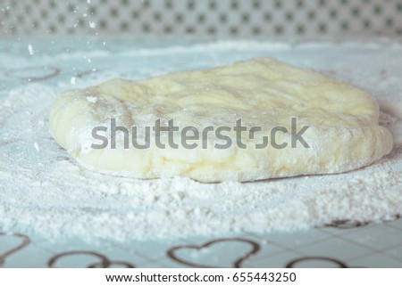 The rolled out dough sprinkled with flour on the table