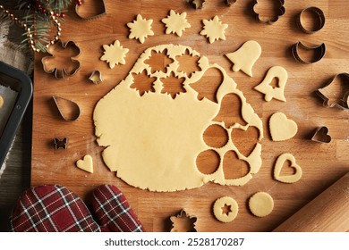 Rolled out pastry dough with cut out shapes on a wooden board - preparation of homemade Linzer cookies, top view - Powered by Shutterstock