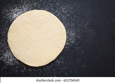 Rolled Out Pizza Dough On Floured Slate Surface, Photographed Overhead With Natural Light