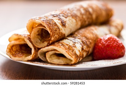 Rolled Pancakes With Powdered Sugar And Strawberry