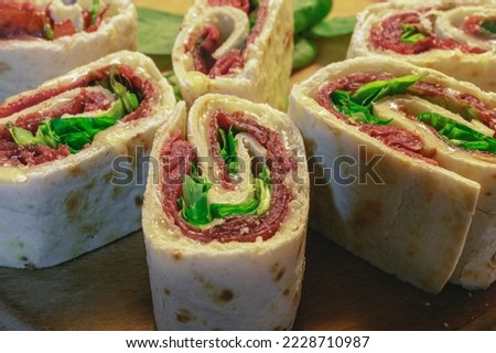 A rolled piadina with bresaola cheese and salad