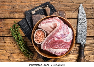 Rolled Pork belly, raw meat in a wooden plate with thyme. Wooden background. Top view - Powered by Shutterstock