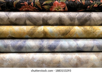 Rolled up rolls of vinyl wallpaper. Different textures and colors, as background. Wallpapers with abstract patterns for the wall. Decorative  materials for renovation of room, interior
