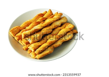 Rolled stack of buttery yeast dough sticks with rosemary and goat's milk isolated on a plate on a white background