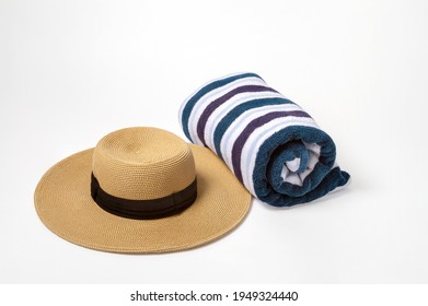 Rolled Striped Beach Towel And A Large Brown Brim Hat With A White Background 