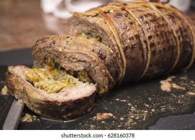 Rolled And Stuffed Flank Steak Sliced On A Cutting Board