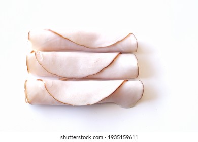 Rolled White Chicken Or Turkey Sliced Meat. Top View On White Background With Copy Space