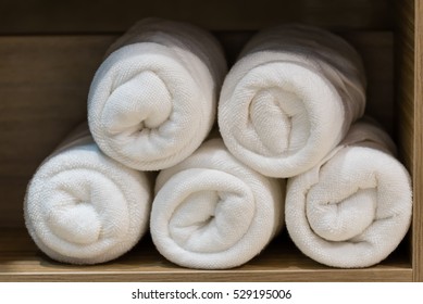 Rolled White Cotton Towel In A Wood Cupboard