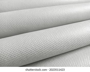 rolled white polypropylene fabric. non-woven fabric background with fibrous texture. industrial bag material