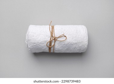 Rolled white towel tied with a rope on gray paper background. - Shutterstock ID 2298739483