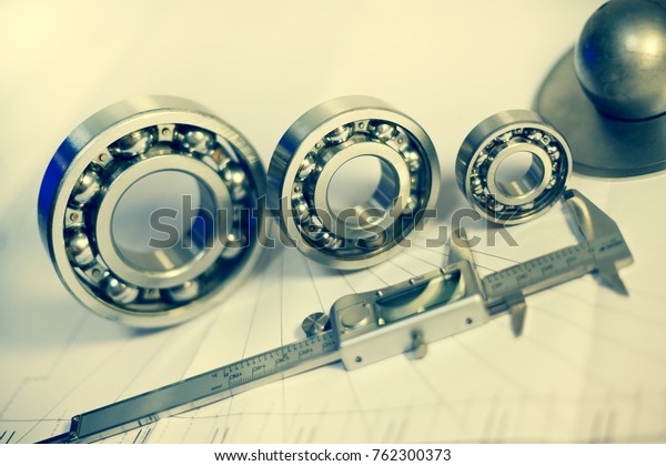 Roller bearings of different diameters and\
electronic calipers,\
toned