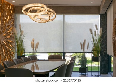 Roller blinds in the interior. Automatic solar shades large size on the window. Modern interior with wood decor panel on the wall. Green plants in hi-tech flower pots. Electric curtains for home.  - Shutterstock ID 2186770415