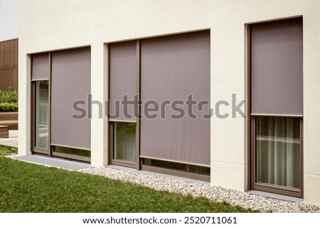 Roller Blinds Outside Window. Panoramic External Blinds Exterior Shades on Large Windows of Modern House Facade. 