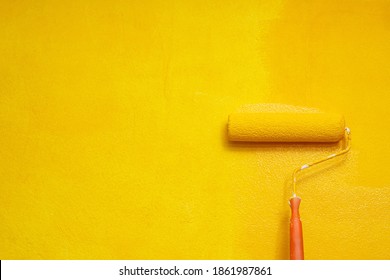 Roller Brush Painting, Worker painting on surface wall  Painting apartment, renovating with yellow color  paint. Leave empty copy space to write descriptive text beside.