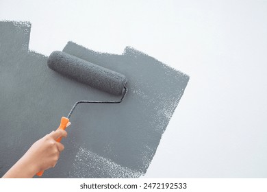 Roller Brush Painting, Worker painting on surface wall  Painting apartment, renovating with grey color  paint. Leave empty copy space white to write descriptive text beside. - Powered by Shutterstock