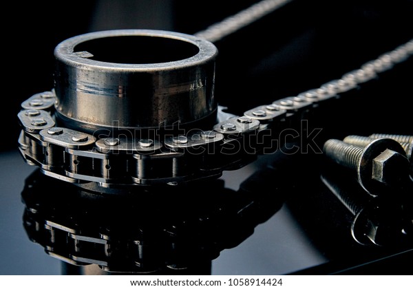 Roller chain with sprocket on dark\
background. It is used on cars, motorcycles, bicycles and in\
mechanical engineering. Can be used as a\
background