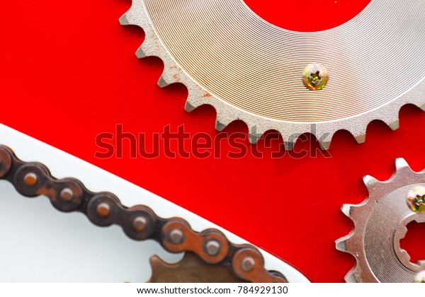 Roller chains with sprockets for motorcycles\
on red background