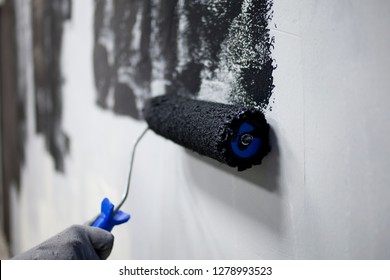 Roller closeup in the hands of a painter