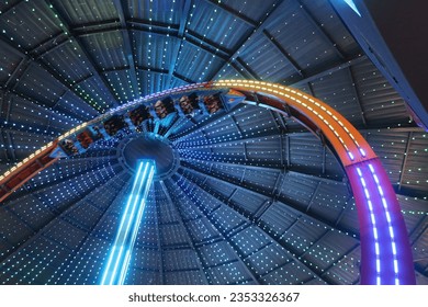 A roller coaster in a dark indoor structure illuminated with thousands of colored lights - Powered by Shutterstock