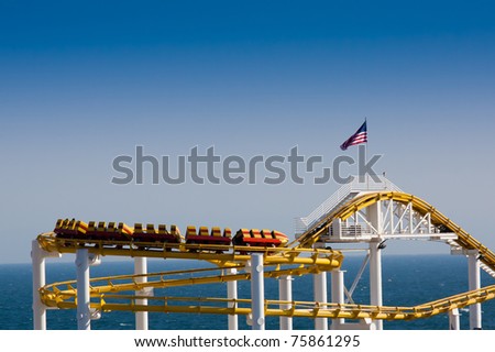 Roller Coaster on Clear Sky and Ocean Background with American Flag