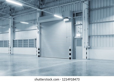 Roller Door Or Roller Shutter Using For Factory, Warehouse Or Hangar. Industrial Building Interior Consist Of Polished Concrete Floor And Closed Door For Product Display Or Industry Background.