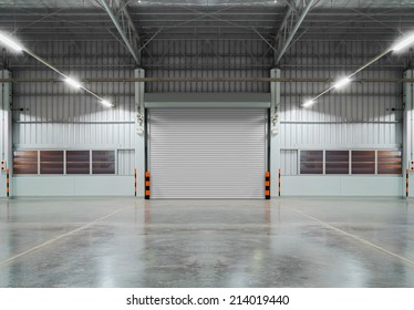 Roller Door Or Roller Shutter Using For Factory, Warehouse Or Hangar. Industrial Building Interior Consist Of Polished Concrete Floor And Closed Door For Product Display Or Industry Background.