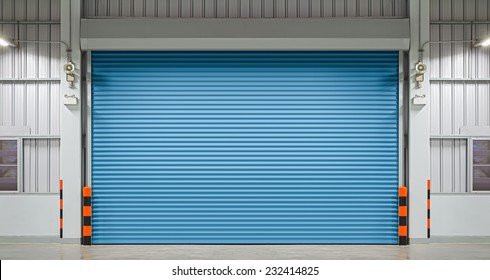 Roller Door Or Roller Shutter Using For Factory, Warehouse Or Hangar. Industrial Building Interior Consist Of Polished Concrete Floor And Closed Door For Product Display Or Industry Background.